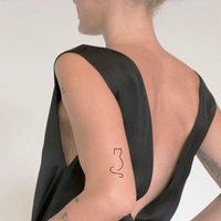 Minimalist one-line cat tattoo.
