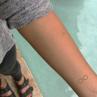 Minimalist one-line infinity logo tattoo.