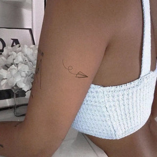 Paper airplane tattoo with dotted trail