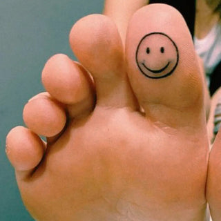 Tatouage Smiley sourire d'un trait épais et minimaliste